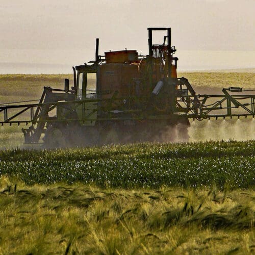 Traktor verteilt Pestizide auf einem Acker